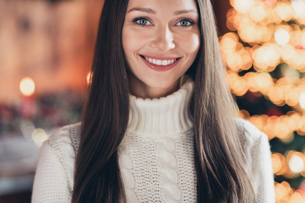 照片：梦幻迷人的年轻女子，身穿白色套头衫，在室内房屋房间里微笑着许愿。图片下载