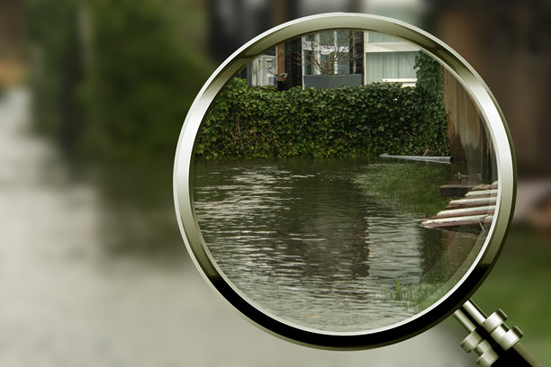 聚焦洪水：用放大镜聚焦进入房屋的水。照片展示了聚焦和保护海洋，以及聚焦洪水和气候变化。图片下载
