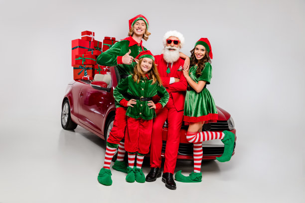 照片，酷炫开心的圣诞老人助手们穿着服装，骑着红色车辆送礼物，竖起大拇指，面带微笑，孤立在白色的背景上。图片下载