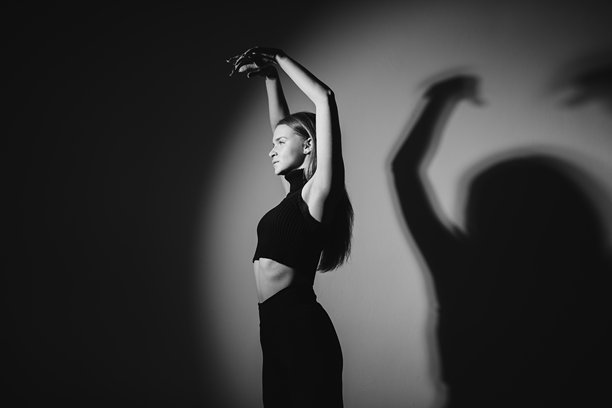 工作室里，一位优雅的现代舞者正在摆出优美的姿势。黑白照片。图片下载