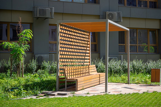 带长凳的木制凉棚，位于景观庭院中。现代凉棚和植物打造的户外休息区。实景照片图片下载