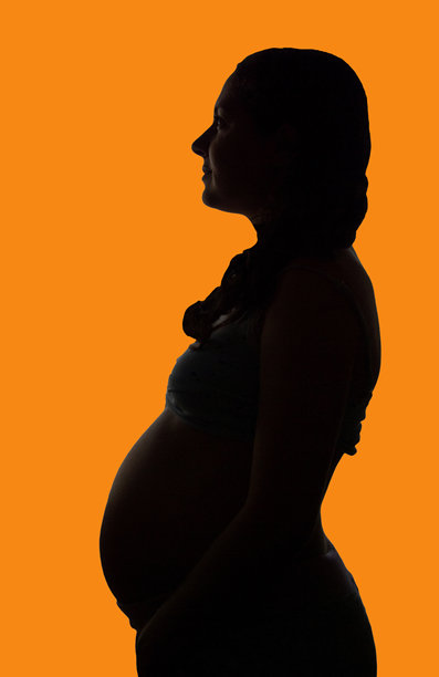 孕妇剪影侧面照，橙色背景图片下载