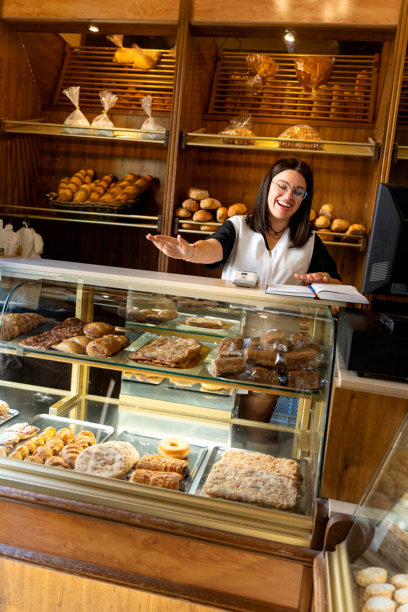 Woman selling fresh baked goods in bakery图片下载