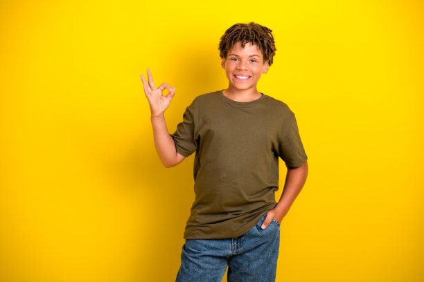 一个活泼快乐的男孩穿着休闲卡其布T恤和牛仔裤，展现出轻松随和的氛围，适合作为生动愉快的图片素材。图片下载