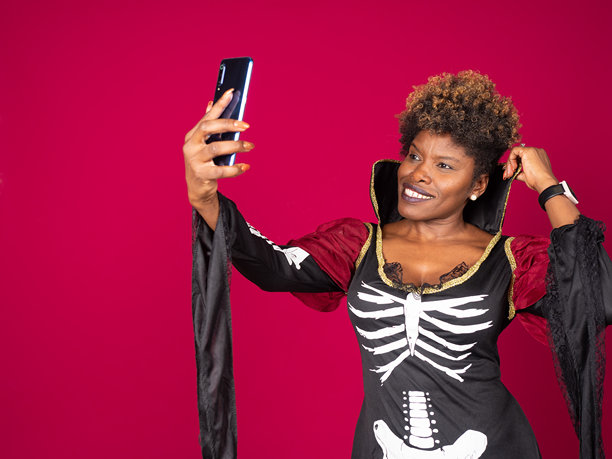 身穿骷髅服装的女性正在自拍万圣节照片图片下载