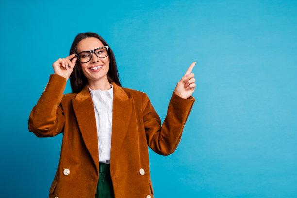 自信的女商人在复古风格的西装外套中，带着积极的态度，在生动的蓝色背景下展现出专业魅力。图片下载