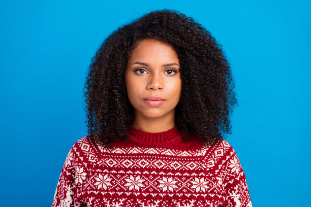 照片：穿着印花毛衣的可爱自信女性，背景为蓝色图片下载