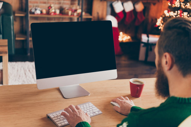 穿着毛衣的程序员在办公室低头工作，这是他背部对着镜头的照片，他看起来很专注，办公室室内。图片下载