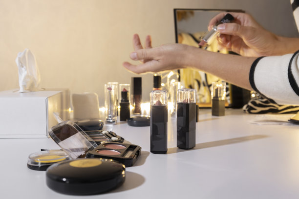 一位女士在美妆店的化妆品柜台附近，在手腕上试用柔和的粉色口红，以比较颜色并为她的服装挑选合适的口红。图片下载