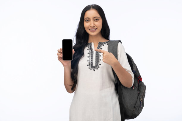 身穿库尔塔、隔离在白色背景上的年轻女学生展示手机屏幕的图片素材图片下载