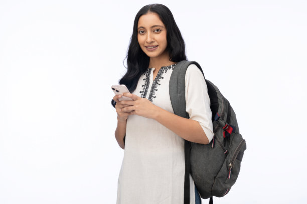 年轻女学生穿着库尔塔，在白色背景下使用手机的库存照片图片下载