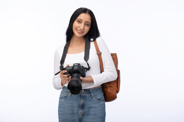 年轻女子手持相机肖像，在白色背景下享受一天的隔离镜头，素材照片图片下载