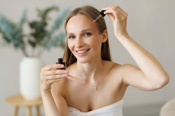年轻女子头裹浴巾肖像，孤立在留白处，用滴管涂抹精油。 |Portrait with young woman in bath towel on head isolated on copy space applying oil serum from pipette.图片下载