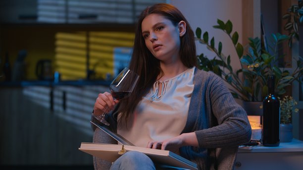 一位三十多岁的家庭主妇，独自在家，晚上看着相册，喝着酒，回忆着往事，情绪低落，带着懊悔，在晚间的公寓里放松。她看起来有些酗酒的迹象，但主要还是在独自面对自己的思绪，看着旧照片，借酒消愁，试图在酒精的麻痹下寻找片刻的宁静，但内心依旧被过往的遗憾所占据，显得有些忧伤和失落，是那种一个人在深夜里，对着过去的点点滴滴，借酒浇愁的女性形象。图片下载