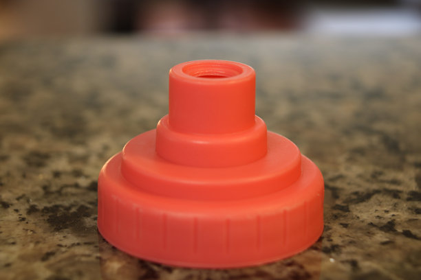 花岗岩台面、橙色塑料水瓶、静物构图图片。图片下载