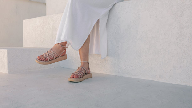 Woman's feet in sandals on a white background图片下载