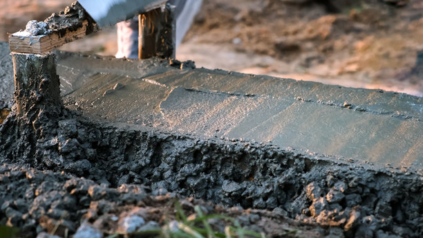 建筑工地上，湿混凝土被倒入模板中。水泥砂浆混合物。基础工程。基础侧视图。高质量照片图片下载