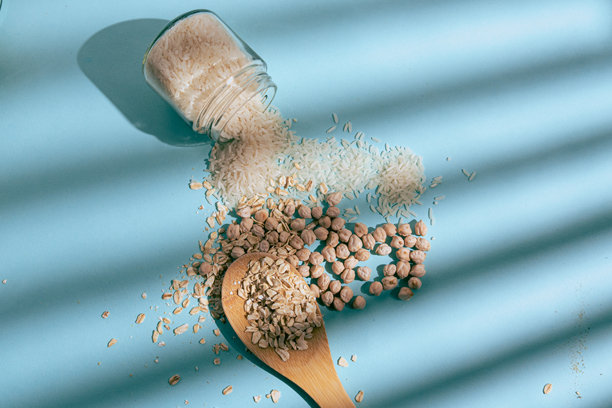 俯视拍摄的天然谷物和谷类照片，包括燕麦、大米和鹰嘴豆，构图简洁，光线自然。图片下载