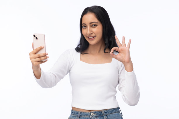 身穿白色T恤的年轻女孩使用手机，白色背景下的素材照片图片下载