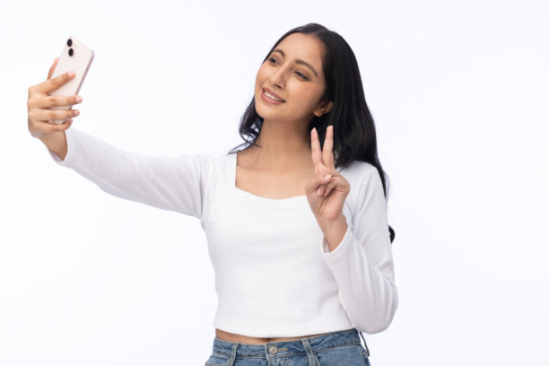 身穿白色T恤的年轻女孩正在使用手机，纯白背景下的照片素材图片下载