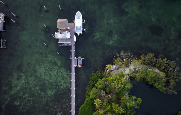 佛罗里达礁岛群伊斯兰诺拉的码头、日落、游艇、海滩和灯塔的航拍照片。茶桌礁和伊斯兰诺拉。图片下载
