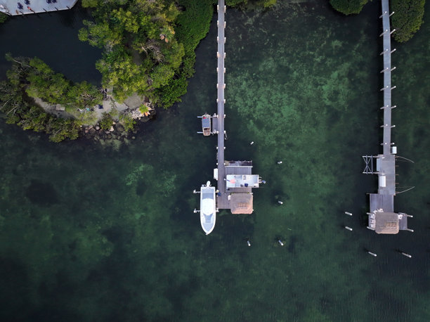 佛罗里达礁岛群伊斯兰诺拉的滨海风光，包括码头、日落、游艇、海滩和灯塔的航拍照片。包括茶桌礁和伊斯兰诺拉。图片下载