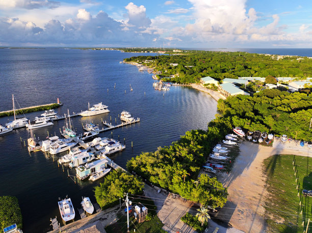 佛罗里达群岛伊斯兰诺拉的码头、日落、游艇、海滩和灯塔的航拍照片。茶桌岛和伊斯兰诺拉。图片下载