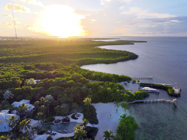 佛罗里达群岛伊斯兰诺拉的空中照片，展示了码头、日落、游艇、海滩和灯塔。包括茶桌岛和伊斯兰诺拉。图片下载
