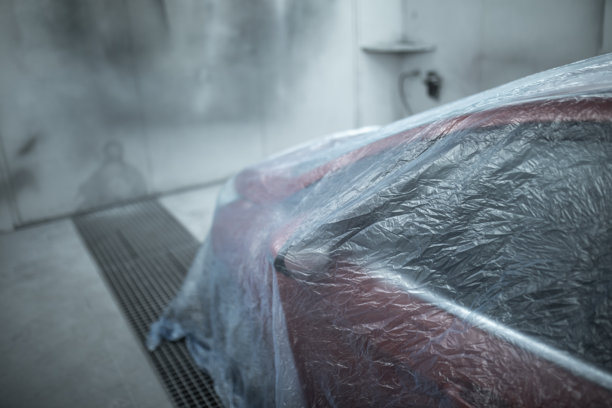 汽车漆面保护膜覆盖的豪华汽车，在专业的汽车喷漆房中被拆卸和准备喷漆。汽车维修服务中的车辆喷漆过程。素材图片图片下载