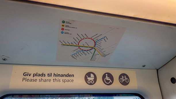 丹麦哥本哈根的火车车厢内部，窗户上方显示着哥本哈根地铁地图和公共交通图标。图片下载