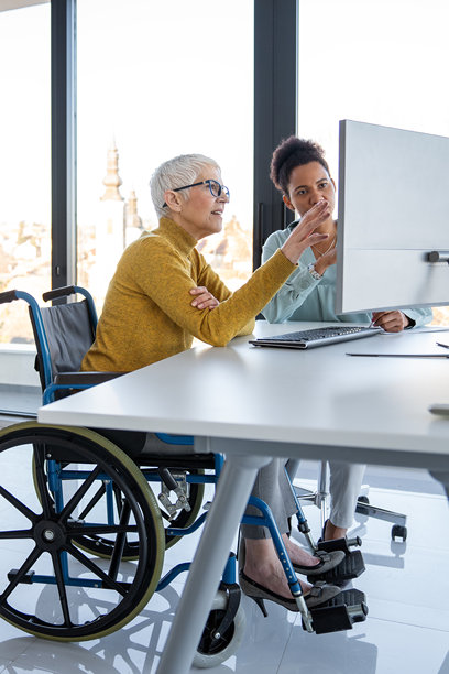 图片展示了一位使用轮椅的人，体现了现代办公室的包容性和团队合作。图片下载