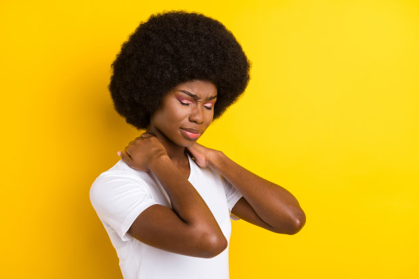 照片：不开心、生病的年轻黑皮肤女性，手捂着脖子，脖子疼痛，患有疾病，孤立在黄色背景上。图片下载