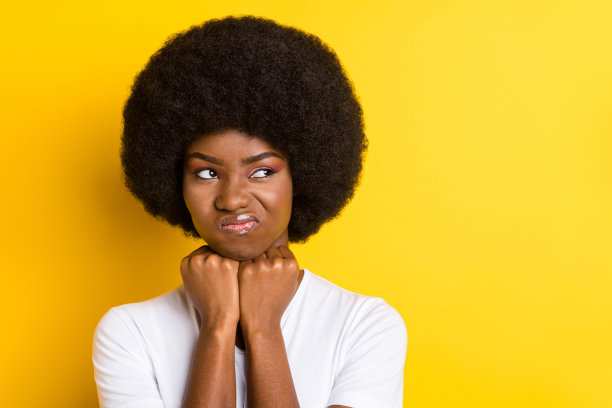 照片：一个脸色阴郁、黑皮肤的年轻女子，表情悲伤，眼神空洞，心情糟糕，孤立在黄色背景上。图片下载