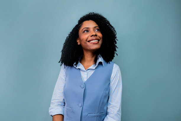 一位自信的女商人在工作室拍摄的照片中，带着乐观的笑容进行思考图片下载