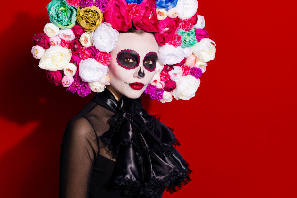 照片，展示了美丽的深色卡特里娜骷髅图案，这是民间传说中的生物，与亲戚、圣徒、荣誉、节日、花卉头饰、黑色传统蕾丝服装相关，孤立在紫色背景上。图片下载