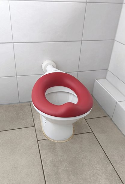 浴室里带有亮红色软座的儿童马桶图片下载