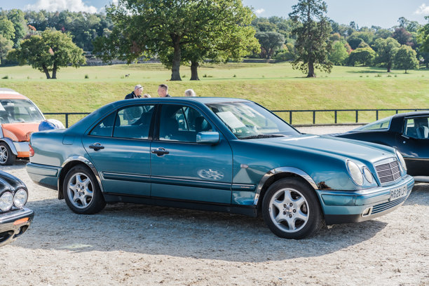 人们在切斯特经典汽车拍卖会上观看一辆青绿色的梅赛德斯-奔驰E级车图片下载