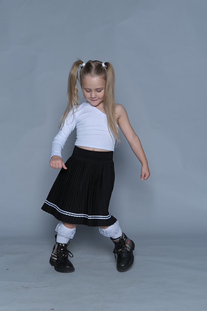 一个5岁的女孩自信地站着，她的姿势体现了力量和赋权。这张图片捕捉到了时尚不仅关乎服装，更是关于表达个性和自信的理念，即使在年幼时也是如此。图片下载