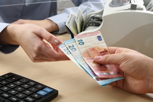 客户在柜台给收银员欧元纸币，特写图片下载
