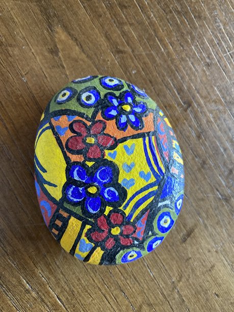 手绘石头，展示多彩民间艺术设计，带有花卉图案和传统的邪恶之眼图案图片下载