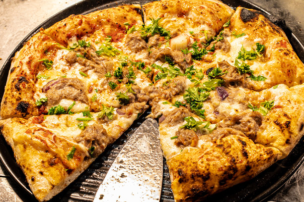 新鲜出炉的美味披萨照片，配有奶酪、番茄酱和各种配料。酥脆的饼底、鲜艳的色彩和诱人的外观使其成为美食、烹饪和餐厅主题的完美选择。图片下载