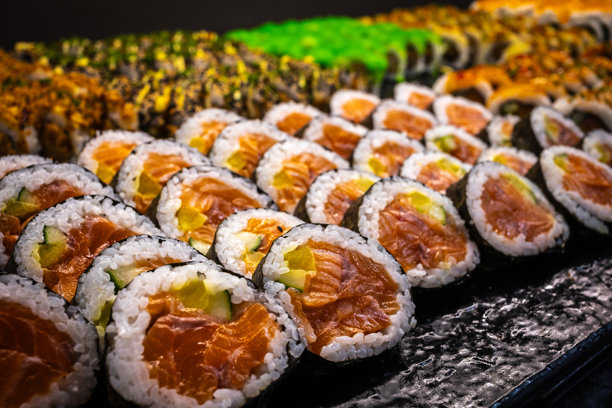 美味的寿司卷照片，盛放在盘子里，包含新鲜的鱼、米饭和海苔。精美的摆盘，色彩鲜艳，非常适合美食、烹饪和餐厅主题。图片下载