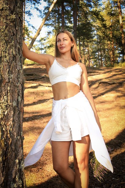 夏日服装的女孩在森林背景下拍摄的温馨照片。与大自然融为一体。呵护自己。高质量照片图片下载