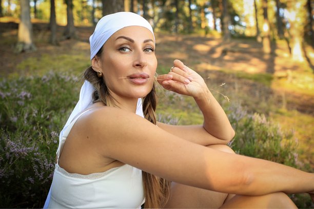 身着白色头巾的女孩在森林背景下与木椅的柔和拍摄。与大自然融为一体。高质量照片。图片下载