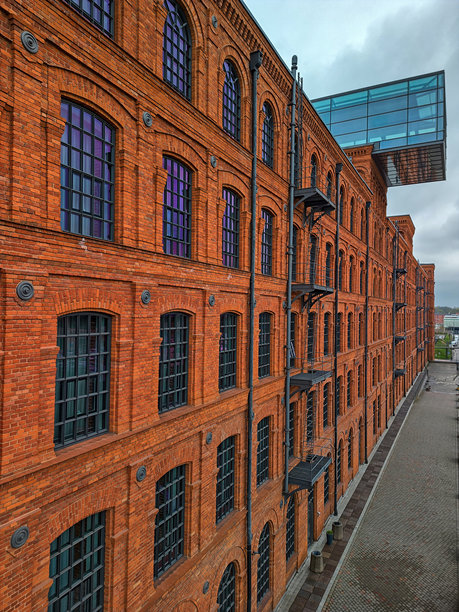 波兰罗兹后工业时代红砖建筑的无人机照片，配有现代玻璃延伸部分，HDR日光图像，适用于社论、房地产和城市更新内容。图片下载