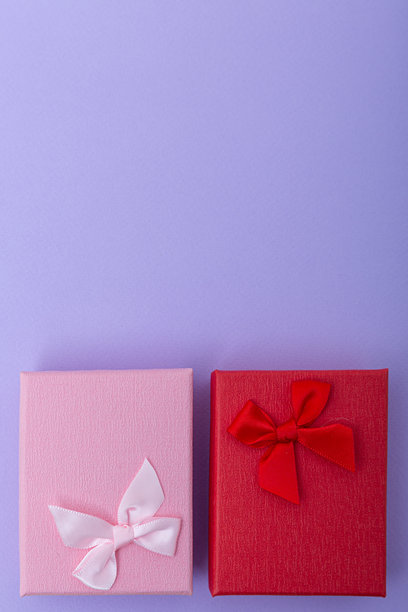 紫色背景上带有丝带的两个精致礼品盒。庆祝、爱与赠予的概念。竖屏照片图片下载