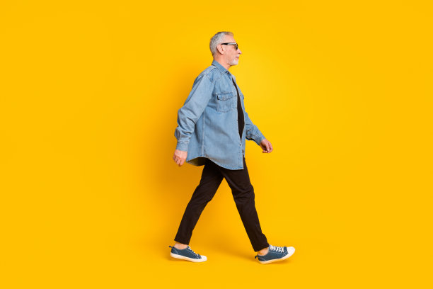 酷炫爷爷的全身个人资料照片，戴着眼镜，穿着夹克和裤子，孤立在黄色背景上图片下载