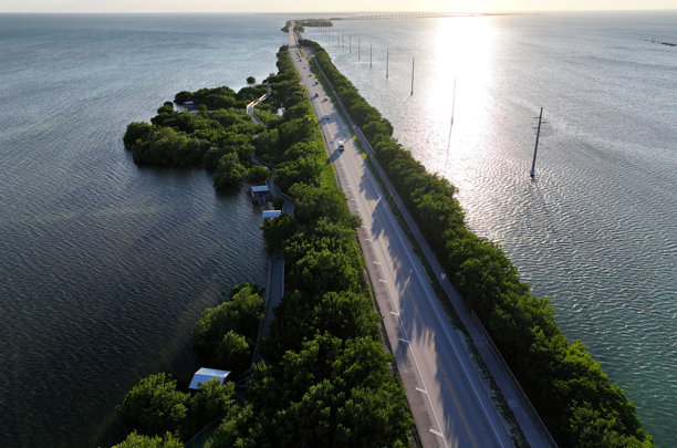 佛罗里达礁岛群伊斯兰诺拉，包含码头、日落、游艇、海滩和灯塔的航拍照片。茶桌岛和伊斯兰诺拉。图片下载