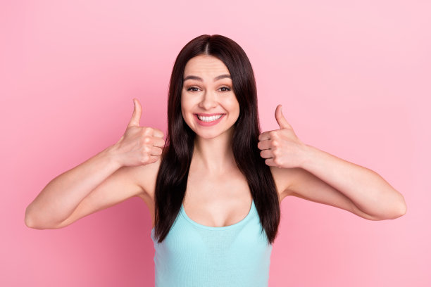 年轻漂亮的女孩开心积极地竖起大拇指，给出建议，做出选择，酷炫地孤立在粉彩背景上图片下载