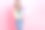 照片：甜美千禧一代女士抱着礼物，身穿蓝色上衣和牛仔裤，在粉色背景前图片下载